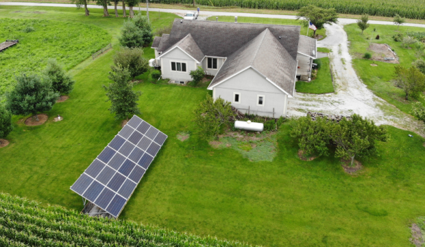 A ground mound solar array is in the backyard of a single family home. The photo was taken by a drone