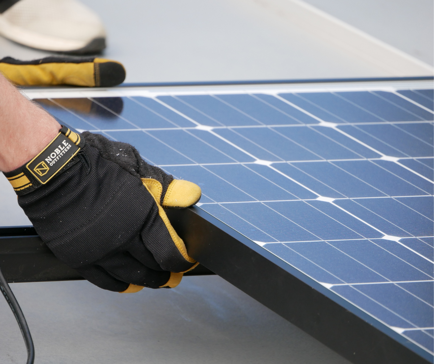 A gloved hand holds a solar panel